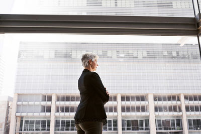 Full length of woman standing against building