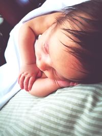 Close-up of baby girl sleeping on bed