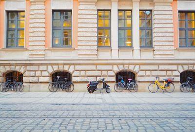 Bicycles and motorcycle parked on street against building