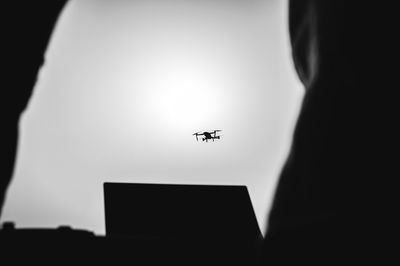 Close-up of silhouette airplane flying in the sky