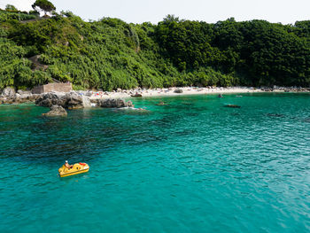 High angle view of boat in sea against mountain