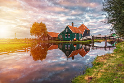 Reflection of trees and buildings in lake against sky