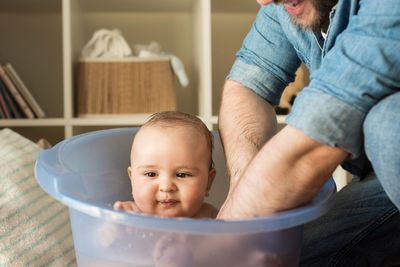 Father bathing son in bucket