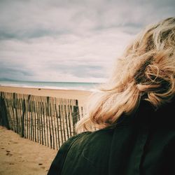 Close-up of woman at beach against sky