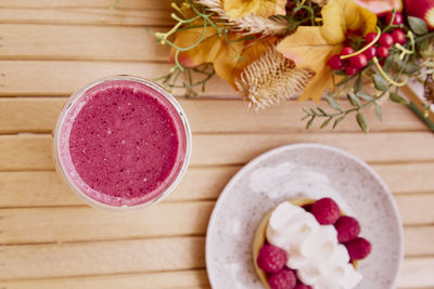 Healthy pink raspberry smoothie with french tart with autumn decorations. aesthetic breakfast