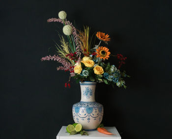 Close-up of flower vase on table against black background