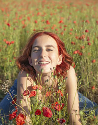 Portrait of young woman sitting on field