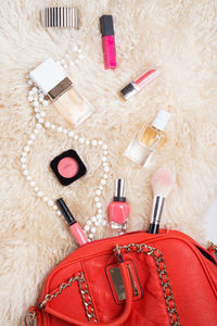 High angle view of beauty products with purse on table