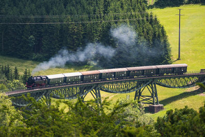 View of steamtrain on metal railroadbridge near epfenhofen in blackforest