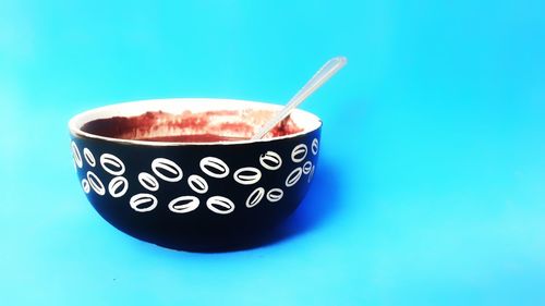 Close-up of coffee cup against blue background