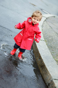 Portrait of happy girl playing in puddle