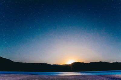 Scenic view of lake against sky at night