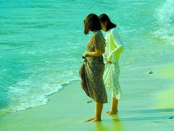 Rear view of women standing on beach