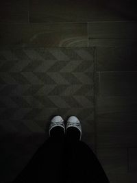 Low section of man standing on hardwood floor