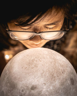 Close-up of woman by illuminated sphere