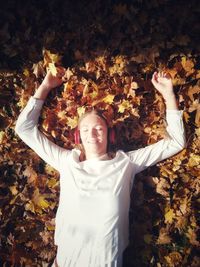 Young woman standing with autumn leaves