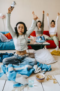 Young woman winning while playing video game at home