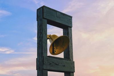 Close-up of bell hanging against sky