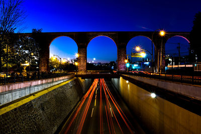 Light trails on road against sky at night