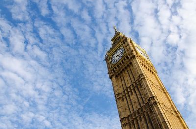 Low angle view of clock tower against cloudy sky