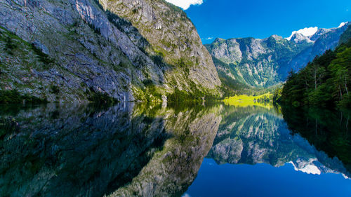 Scenic view of lake by mountain against sky