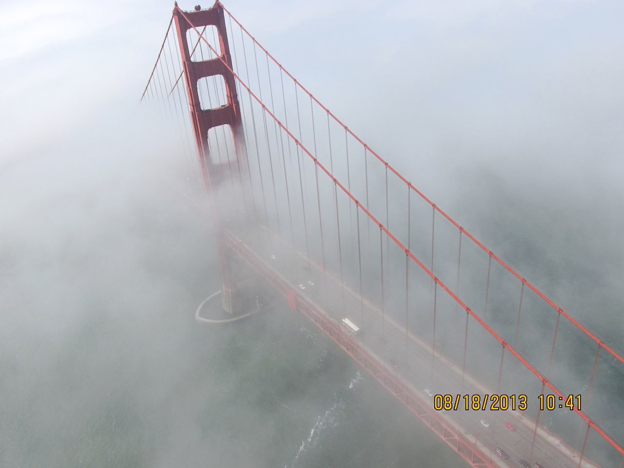 VIEW OF SUSPENSION BRIDGE WITH RAINBOW IN BACKGROUND