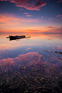 Boat on lake against sky during sunset 