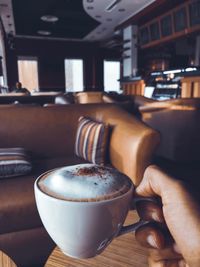 Close-up of hand holding coffee cup