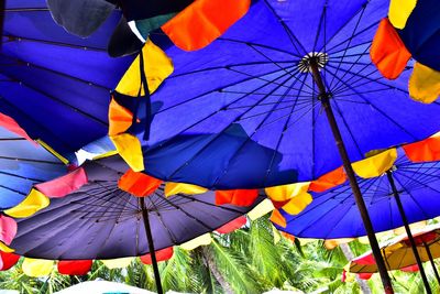 Low angle view of umbrellas against blue sky