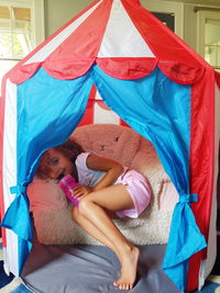 Cute girl playing in tent at home