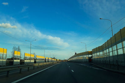 Vehicles on highway against sky in city