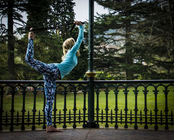 Young woman exercising in gazebo at park