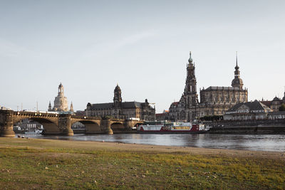 Bridge over river in city against sky