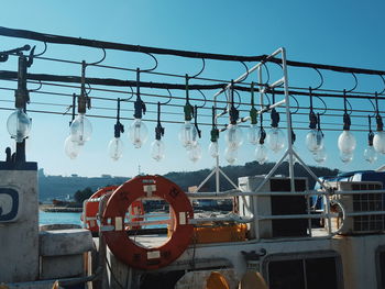 Side view of lights hanging above cropped boat