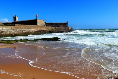 Waves reaching on shore by fort of sao juliao da barra