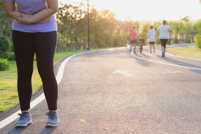 Low section of woman standing on road