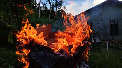 Bonfire on field against orange sky