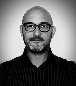 Portrait of man wearing eyeglasses against gray background