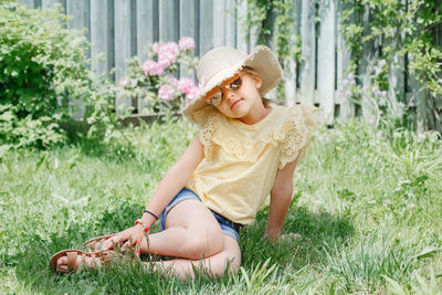 Portrait of girl sitting in grass at yard