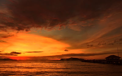 Scenic view of sea against dramatic sky during sunset