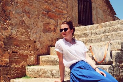 Beautiful young woman sitting on steps