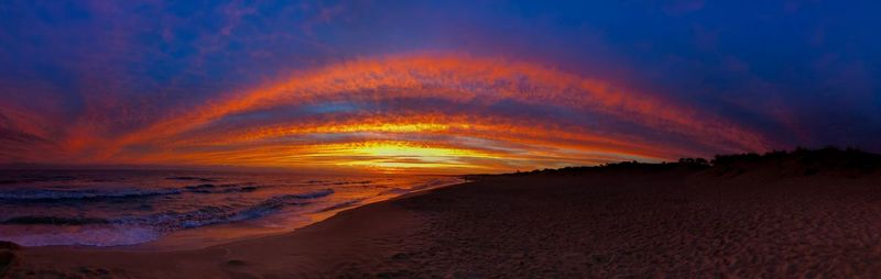 Scenic view of dramatic sky over sea during sunset