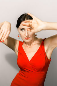 Portrait of young woman with arms crossed standing against wall