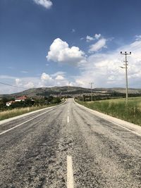 Road passing through land against sky