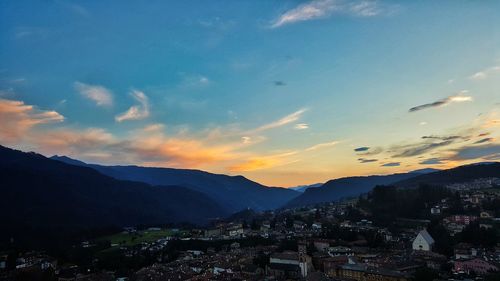 Houses in town against sky during sunset