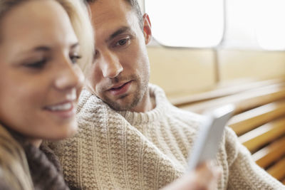 Couple using mobile phone together on ferry