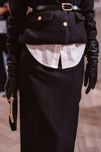 Classic black jacket, leather belt, gloves and classic velvet clutch. fashion model on backstage