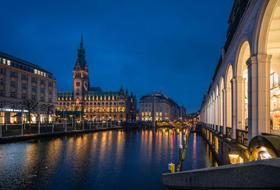 Illuminated buildings by river at night, town hall, hamburg 