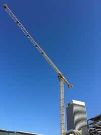 Low angle view of crane against blue sky