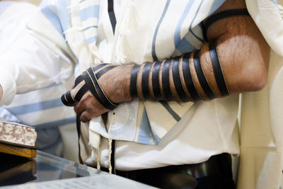 Young man practicing the reading of the torah prior to bar mitzvah celebration. wearing tefillin 